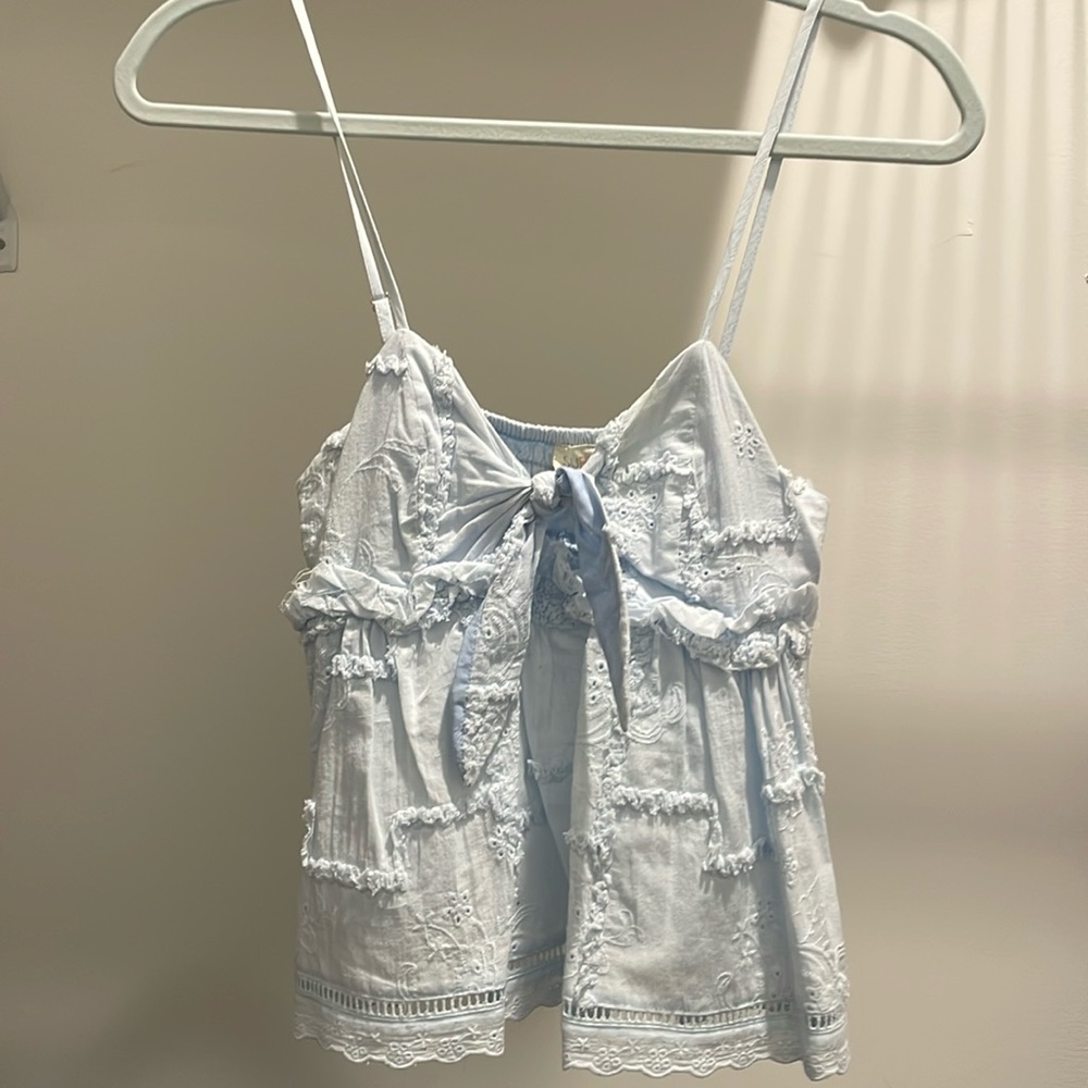 Adorable baby blue tank! The bow is adjustable! Fits more like a small!